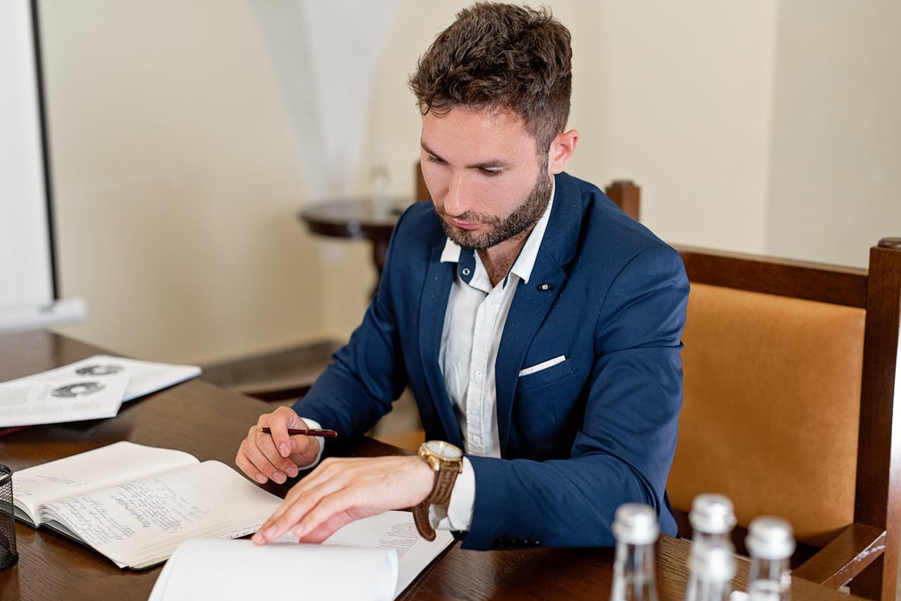 Confident businessman working on documents at a desk in an office setting.